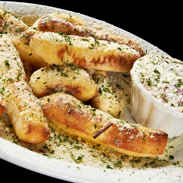 Sally O'Neal's garlic knots, sprinkled with parmesan cheese and parsley, with a side of marinara.
